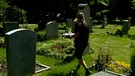 Mann läuft über Friedhof und sammelt Grablichter | Bild: BR