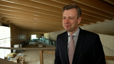 Oliver Bär, Zweckverbandsvorsitzender vom Museum Mödlareuth, steht im Rohbau. | Bild: BR