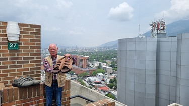 Schuhmacher Georg Wessels in Caracas mit den zwei Paar Schuhen, die für den Venezolaner Jeison Rodriguez bestimmt sind, den Mann mit den aktuell längsten Füßen der Welt. | Bild: Georg und Adrian Wessels