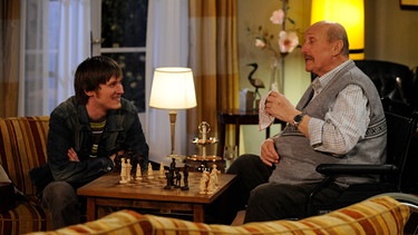Franz bringt Ludwig das Schach spielen bei. Von links: Ludwig Brunner (Martin Wenzl) und Franz Kirchleitner (Anton Pointecker). | Bild: BR/Marco Orlando Pichler