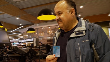 Mann hält Bezahlkarte | Bild: BR