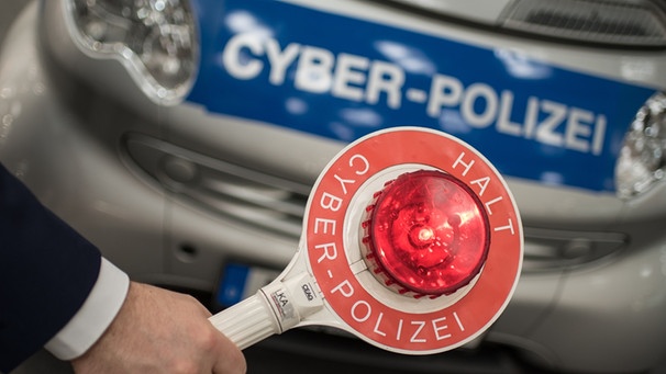 Hand hält Polizeikelle vor Auto mit Aufschrift "Cyber-Polizei" | Bild: picture-alliance/dpa