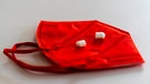 Eine halbierte Tablette auf einer roten FFP2-Maske. | Bild: BR/Raphael Kast