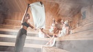 Eine Gruppe von Frauen sitzt in der Sauna und genießen einen Aufguss. | Bild: stock.adobe.com/leszekglasner