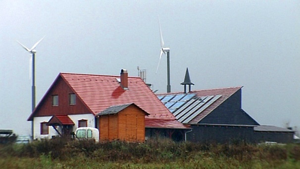Ein Haus mit Solaranlage und Windrädern | Bild: BR
