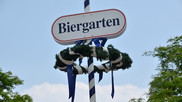 Ein Biergarten-Schild hebt sich in der Karlsaue in Kassel (Hessen) vor einem blass-blauen Himmel ab.  | Bild: picture-alliance/dpa