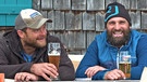 Christian Bauernfeind (l.) und Luis Badrexl sitzen beim Bier vor der Hütte | Bild: BR/Josef Bayer