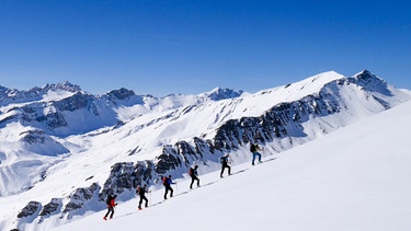 Skitourengruppe im Aufstieg bei strahlendem Sonnenschein | Bild: BR/Michael Düchs