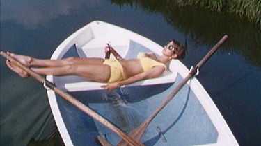 Eine Frau im Bikini sonnt sich in einem Ruderboot | Bild: BR