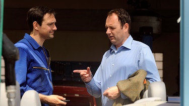 Dahoam is Dahoam. Hubert gibt seinen Wagen zur Reparatur. Von links: Mike Preissinger (Harry Blank) und Hubert Kirchleitner (Bernhard Ulrich). | Bild: BR/Marco Orlando Pichler