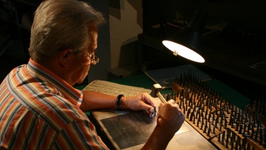 Notenstecher Hans Kühner bei der Arbeit mit Notenvorlage | Bild: BR