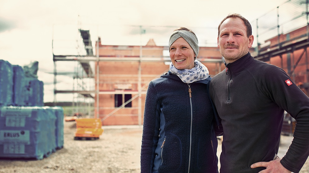 Caro und Andreas Pflügler vor dem Rohbau ihres neuen Bauernhofes | Bild: BR / Vera Johannsen