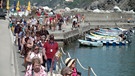 Eine lange Reihe Touristen an einem kleinen Hafen | Bild: BR