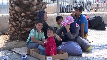 Flüchtlinge sitzen auf der Straße. | Bild: BR