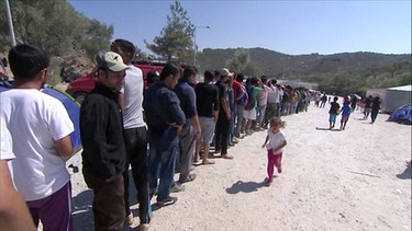 Flüchtlinge stehen in einer Schlange. | Bild: BR
