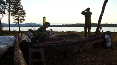 Norwegische Grenzsoldaten machen Feuer am See | Bild: BR