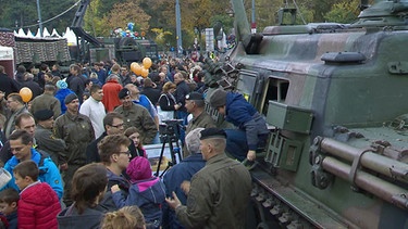 Besucher lassen sich Ausrüstung der Armee erklären. | Bild: BR