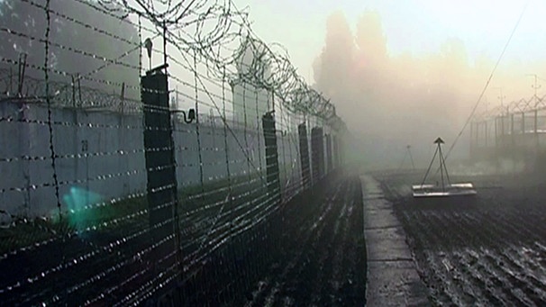 Der mit Stacheldraht geschützte Zaun eines Gefängnisses | Bild: BR