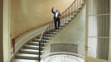 Ein Mann auf einer gewundenen Treppe | Bild: BR