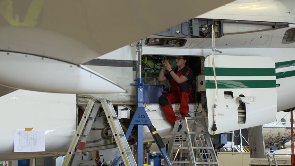 Die Nürnberger Fluggerätelektronikerin Nicole Klein arbeitet an einem offenen Flugzeug. | Bild: BR