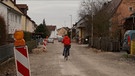 Eine Fahrrad-Fahrerin fährt die Baustelle entlang. | Bild: BR