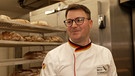 Bäckermeister Andreas Böhm in seiner Backstube vor dem Brot, dass erneut den Staatsehrenpreis bekommen hat. | Bild: BR