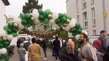 Feiernde Menschen in geschmücktem Hinterhof. | Bild: BR
