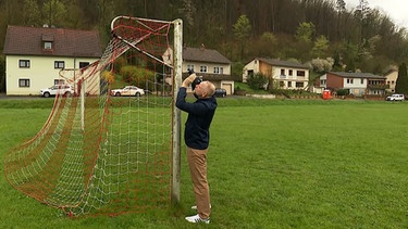 Mann fotografiert Fußballtor. | Bild: BR