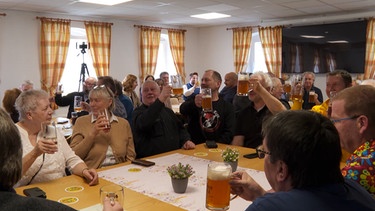 In ganz großer Runde feiern die Wölsauerhammerer ihr Gemeinschaftsprojekt, ihr Wirtshaus ist endlich wieder in Betrieb. | Bild: BR
