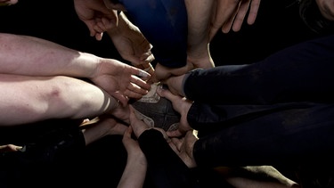 Mehrere Hände halten einen Rugby. | Bild: BR