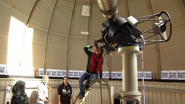 Frau sieht durch Teleskop. | Bild: BR