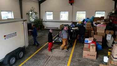 Helfer vom "Helferkreis Plankenfels" bereiten einen LKW mit Hilfsgütern vor. | Bild: BR