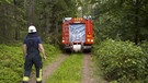Feuerwehrauto fährt durch Wald. | Bild: BR
