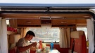 Eric frühstückt in seinem Wohnwagen. | Bild: BR