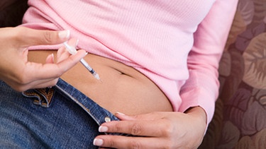 Frau gibt sich selbst Injektion in den Bauch | Bild: picture-alliance/dpa