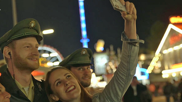 Wiesn-Besucherinnen machen Selfie mit Polizisten | Bild: BR