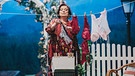 Der Komödienstadel - Rock 'n' Roll im Abendrot: Silvia (Maria Peschek) hängt ihre Wäsche auf eine Leine. | Bild: Julia Müller