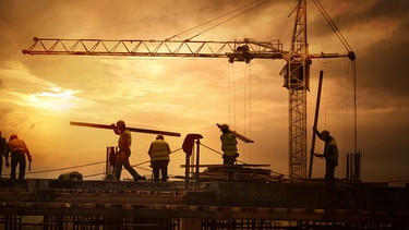 Symbolbild: Baustelle vor dem Sonnenuntergang mit Arbeitern aus dem Ausland | Bild: stock.adobe.com |  Sondem