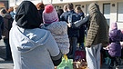 Geflüchtete aus der Ukraine stehen mit ihrem Gepäck vor den Gebäuden eines Flüchtlingsheims. | Bild: picture alliance/dpa | Henning Kaiser