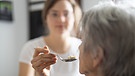 Eine Seniorin wird gefüttert (Symbolbild) | Bild: picture alliance / photothek | Ute Grabowsky
