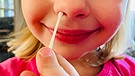 Symbolbild: Ein Kind wird auf Corona getestet, indem ihm ein Wattestäbchen in die Nase eingeführt wird. | Bild: BR