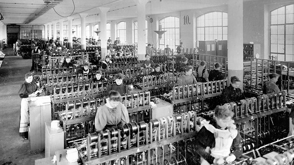 Arbeiterinnen in einem Kabelwerk, 1895 Bildtext: Industriearbeiterinnen arbeiten in einem großen Kabelwerk in der Drahtumspinnerei an ihren Maschinen. | Bild: SZ