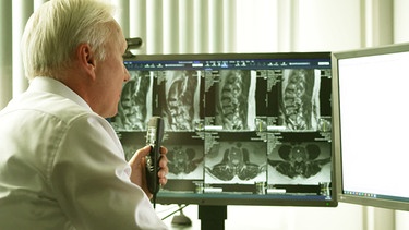 Arzt vor einem Monitor mit Bilder aus dem CT | Bild: BR