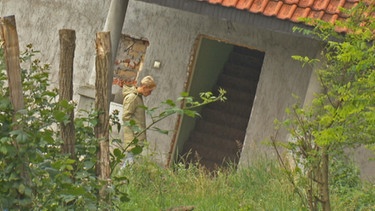 Eine Frau vor einem Haus | Bild: BR