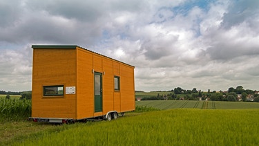 Ein Tiny House auf einer Wiese. | Bild: stock.adobe.com/Christian