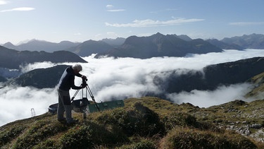 Unter unserem Himmel - Steinböcke in den Allgäuer Bergen: Gerhard Baur bringt seine Kamera in Position.  | Bild: BR