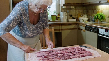 Lore Huber ist Meisterin im Zubereiten der Milzwurst. | Bild: BR/Daniel Delbeck