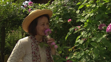 Unter unserem Himmel - Zeit für Rosen: Heilpraktikerin Maria Riedl riecht an einer Rose in ihrem Garten. | Bild: BR