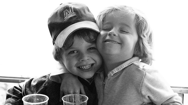 Zwei Jungs im Kindergartenalter, die sich am Tisch umarmen. | Bild: colourbox.com