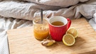 Eine Teetasse mit Honig, Ingwer und Zitrone auf einem Bett | Bild: BR / Leon Baatz